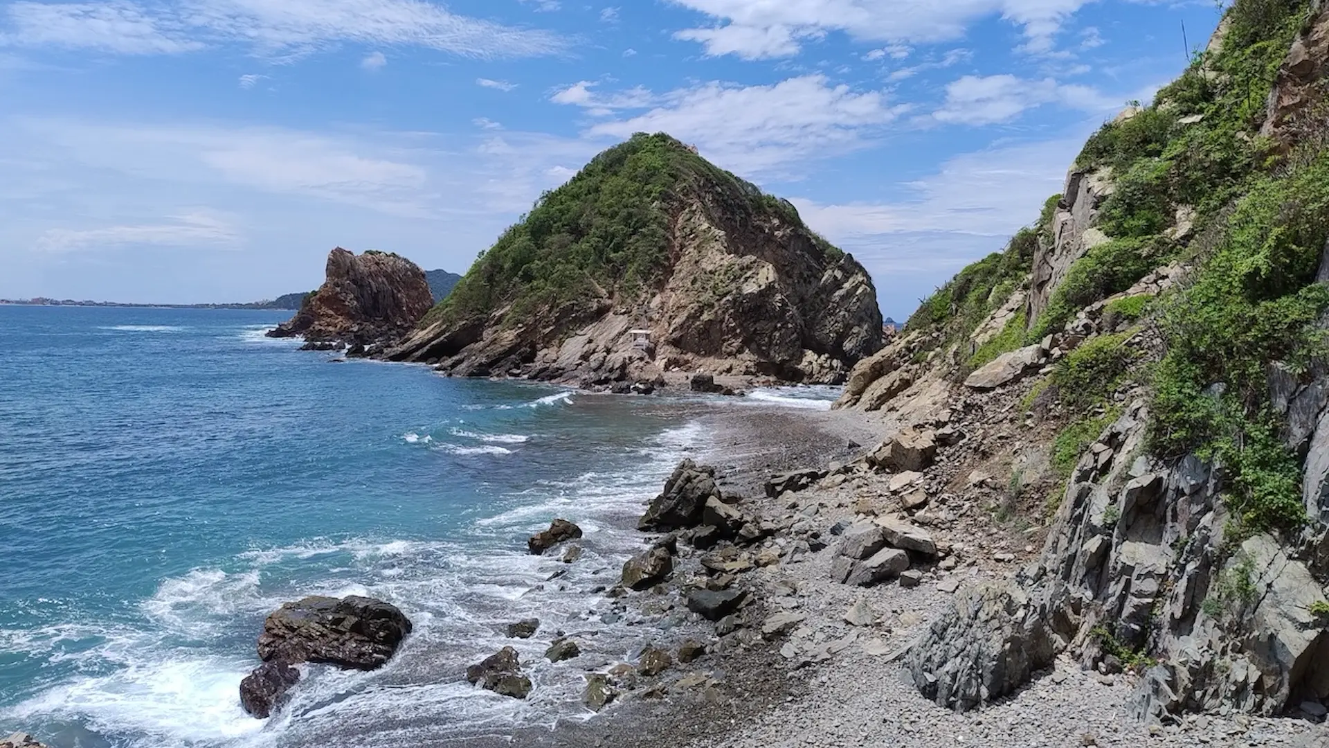The bay of Barra de Navidad in Jalisco is surrounded by rocks and small mountains.